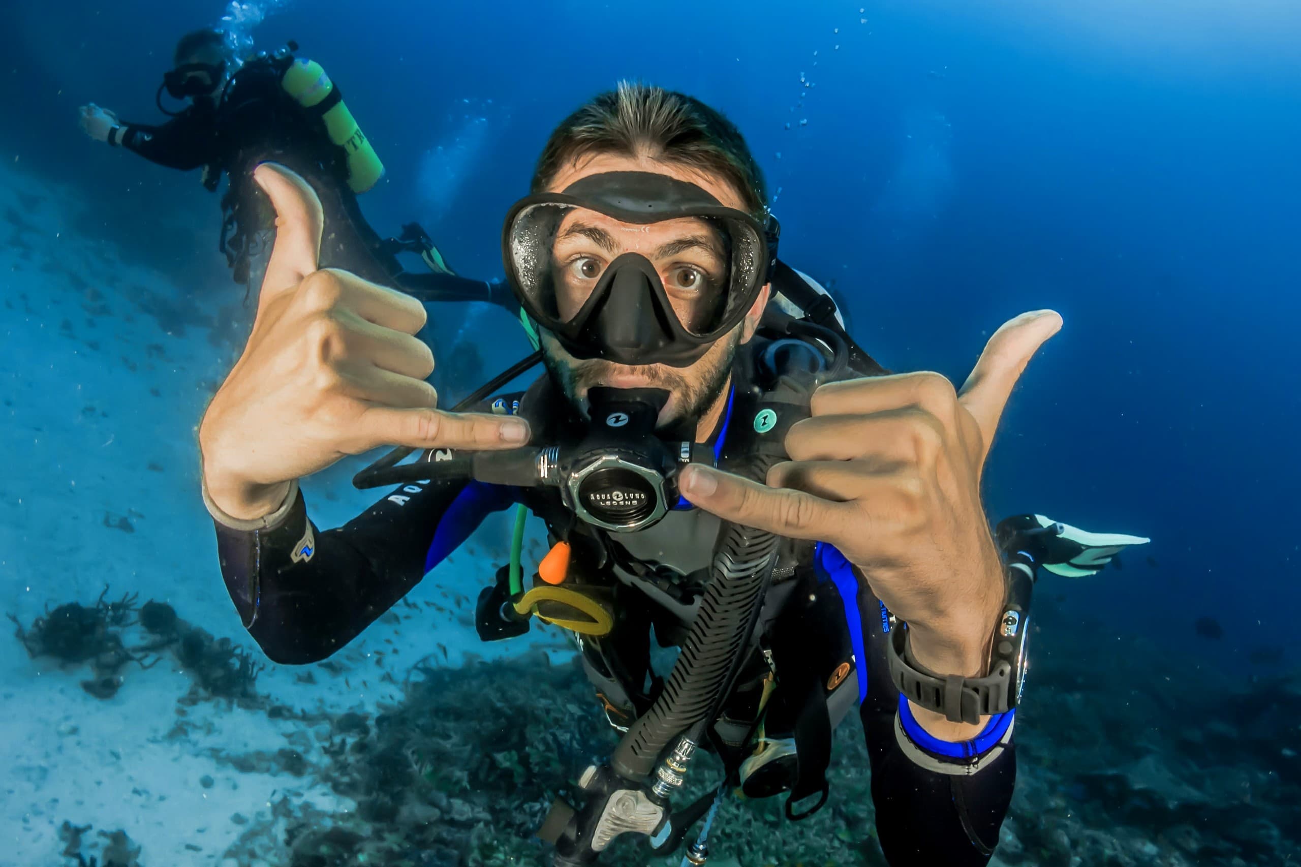Happy scuba diver making a hand gesture underwater