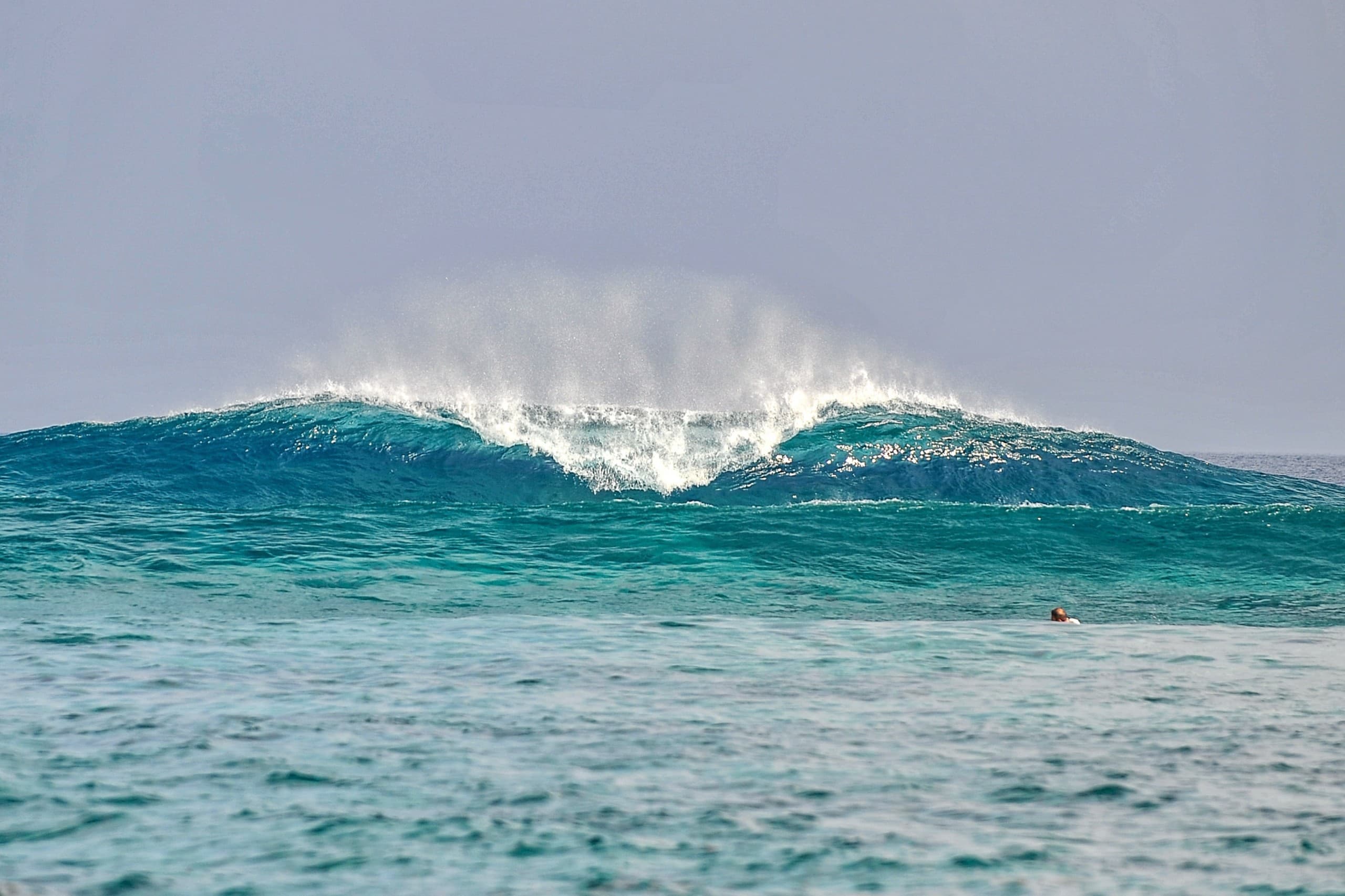 Clean A-frame wave breaking symmetrically over a reef in the Maldives with no surfers in the lineup