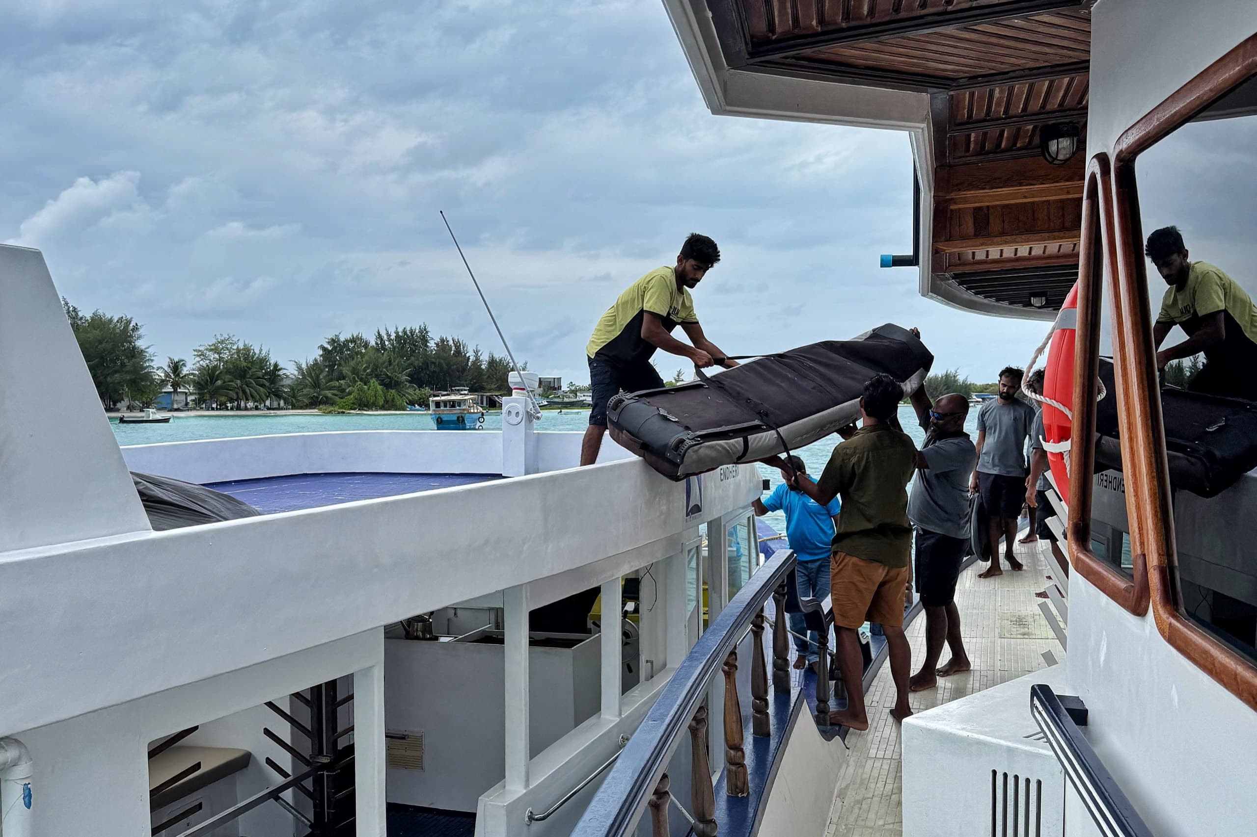 Guests preparing for a surf session from a Maldives liveaboard with boards and gear ready on deck