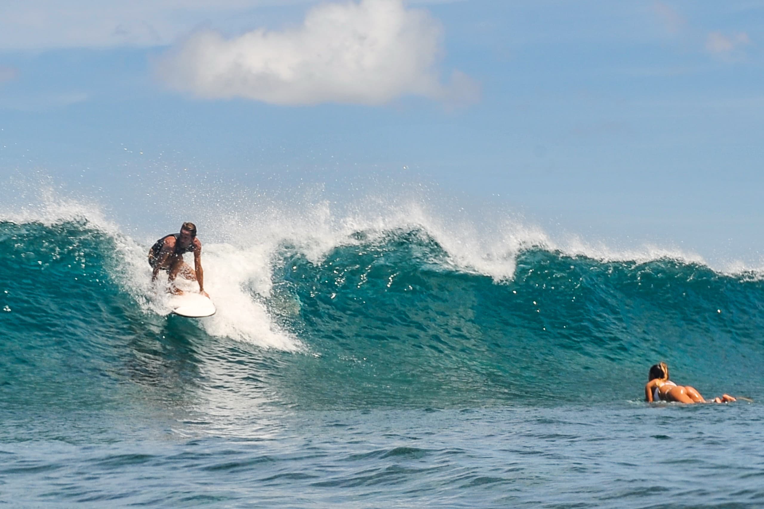 Crystal clear reef break wave in the Maldives with turquoise water and shallow coral bottom