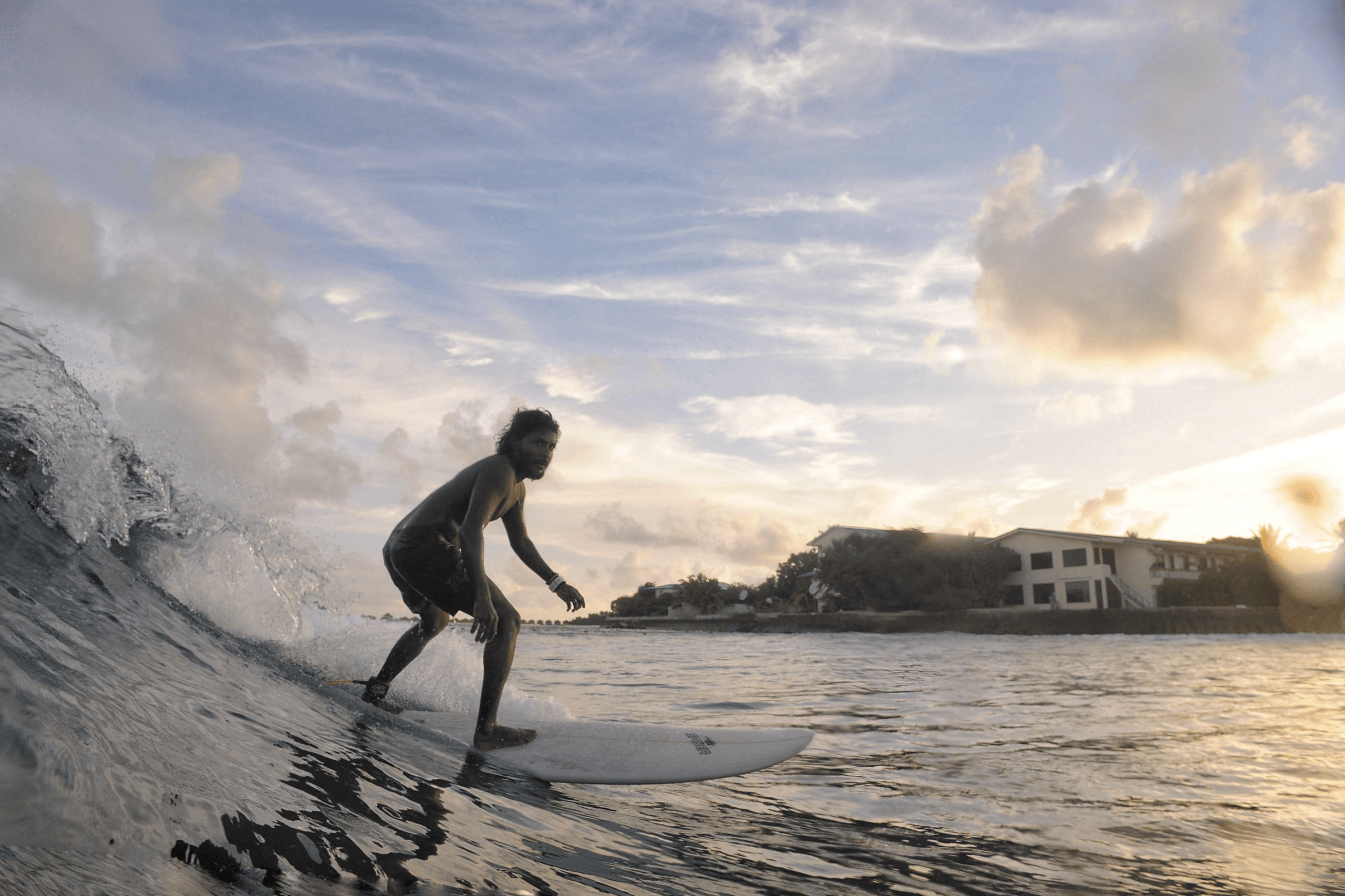 Local surf guide Mickey on a boat in the Maldives assisting guests during a surf trip