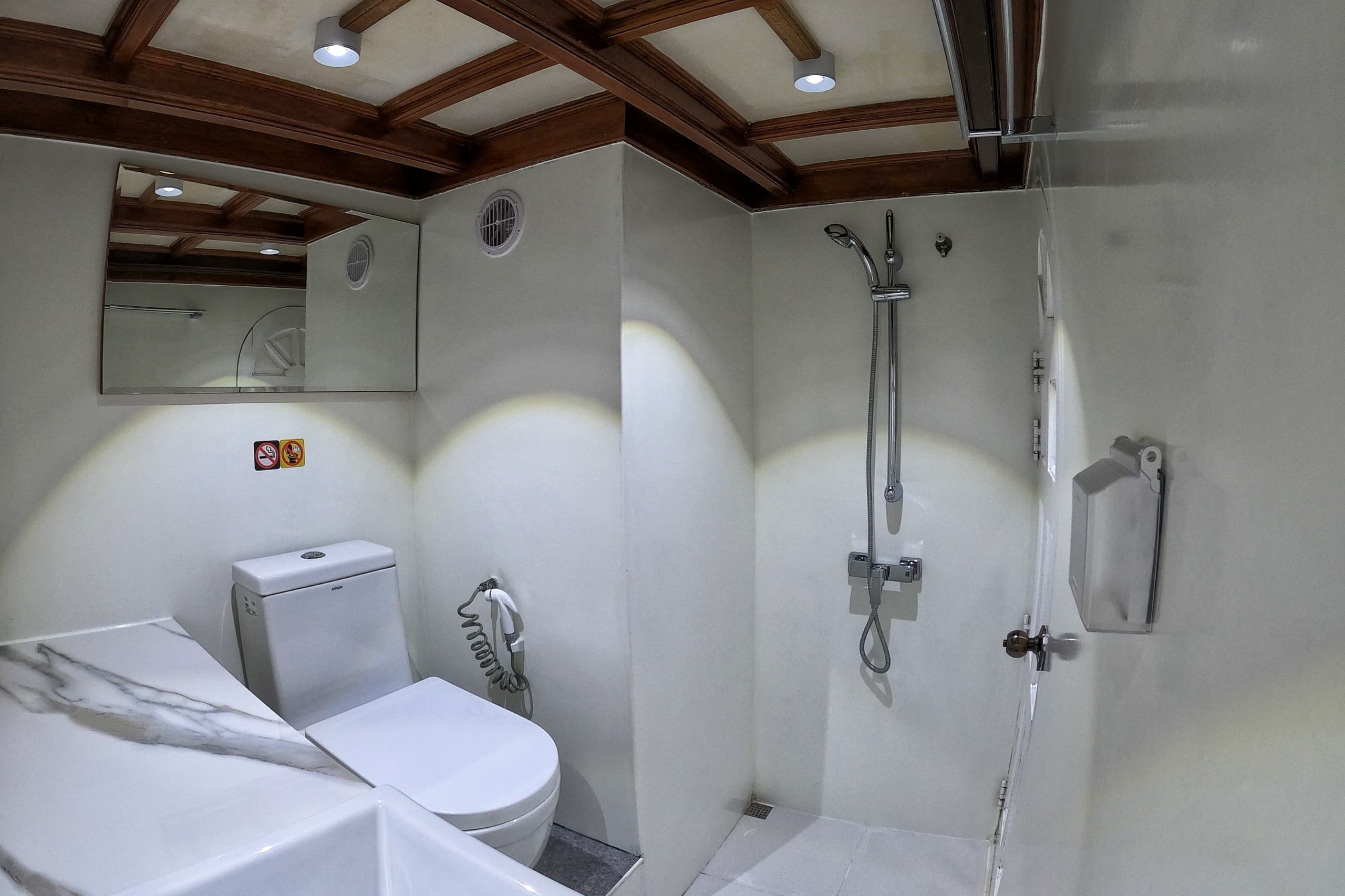 En-suite bathroom with shower inside a cabin on Maavahi liveaboard in the Maldives