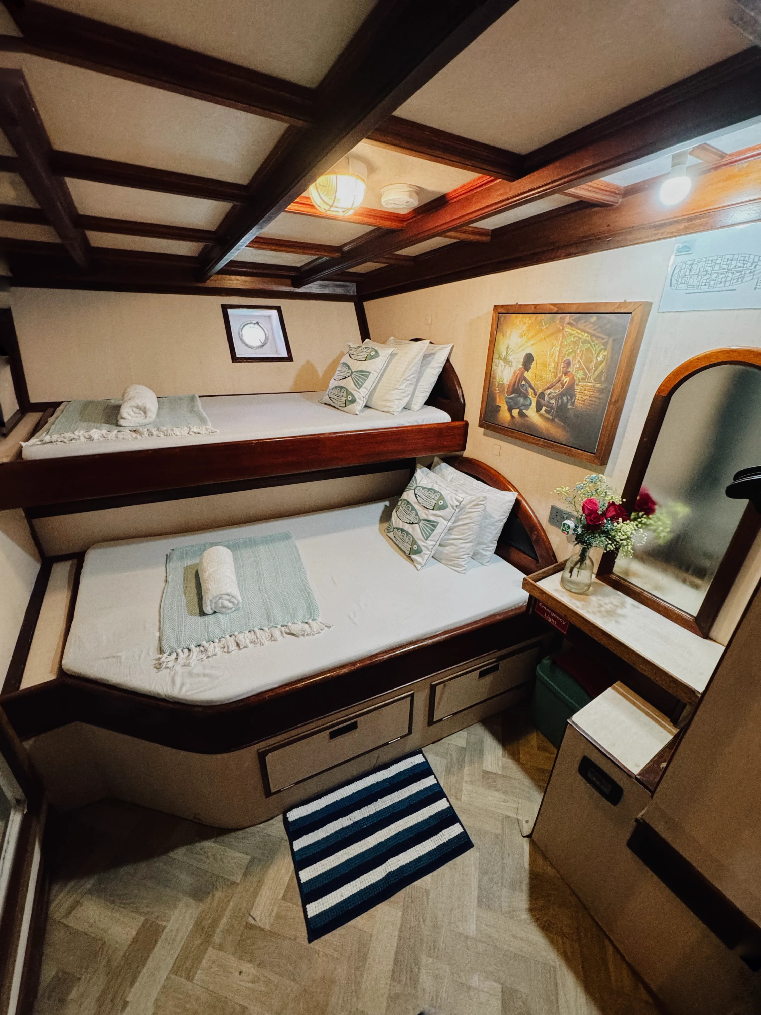 Interior of Maavahi Maldives liveaboard cabin with twin bunk beds and private space