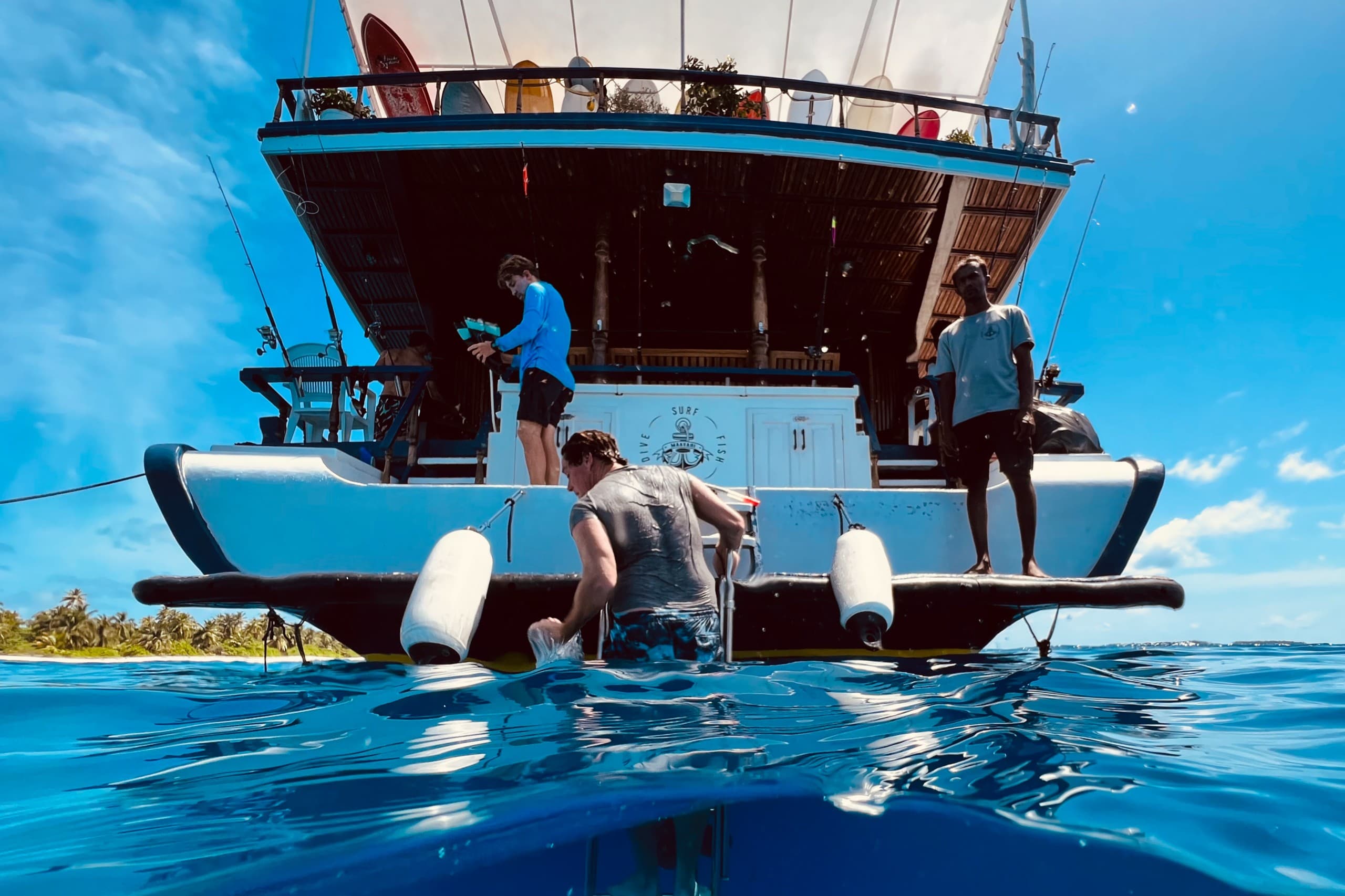Guests boarding Maavahi liveaboard boat from the water in the Maldives ocean