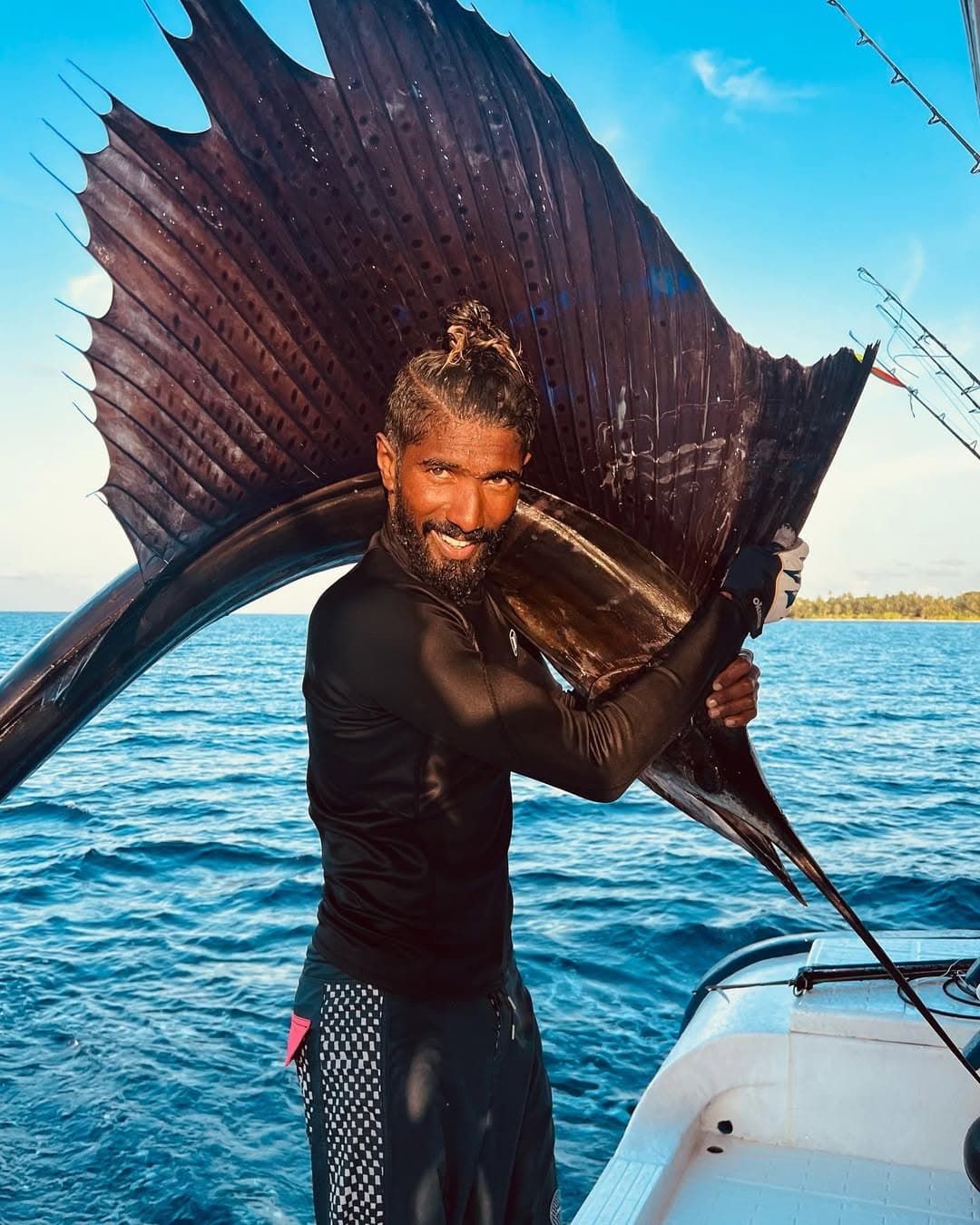 Local guide holding sailfish on boat in Maldives during Maavahi big game fishing experience